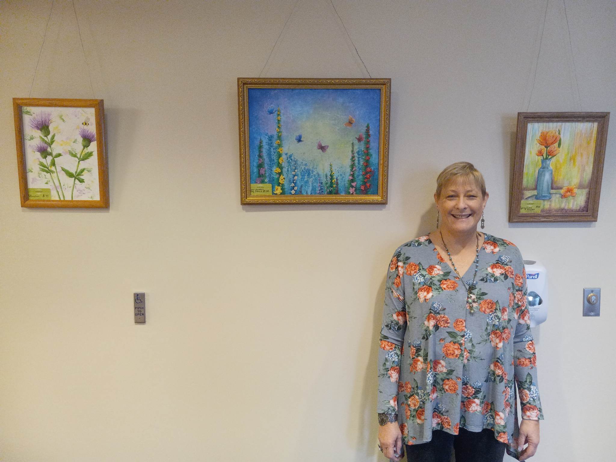 Ruth Whitaker standing in front of her art